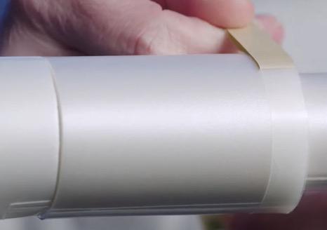 person applying tape to ends of big tube